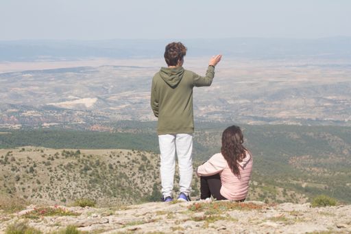 A beautiful couple on the edge of a hill admiring the mesmerizing views of landscapes