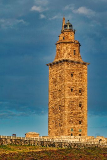 A vertical shot of the Tower of Hercules in La Coruna, Spain under a clouded sky