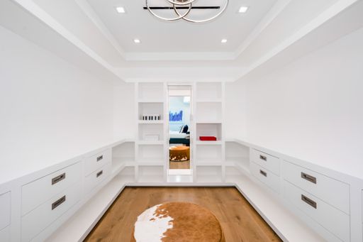 Spacious room with a sizable white bookcase and a cowhide rug
