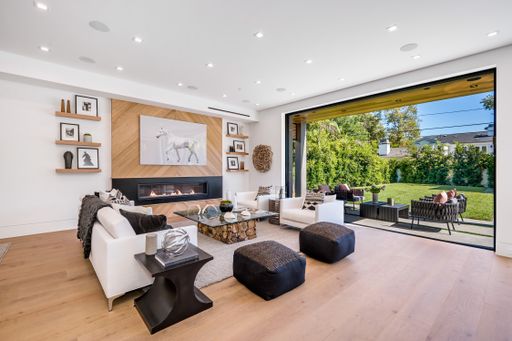 Contemporary living room with a cozy fireplace, comfortable seating, and sliding glass doors