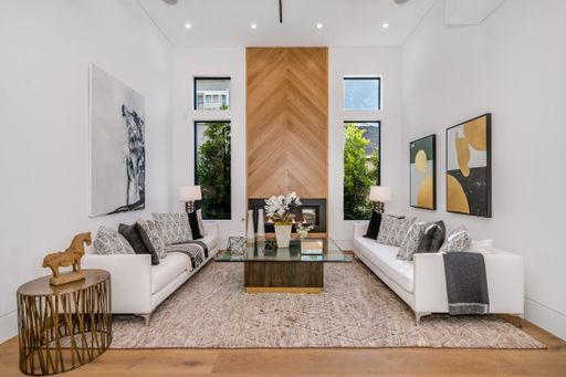 Elegant living room with a spacious, modern design and a large wood paneled fireplace