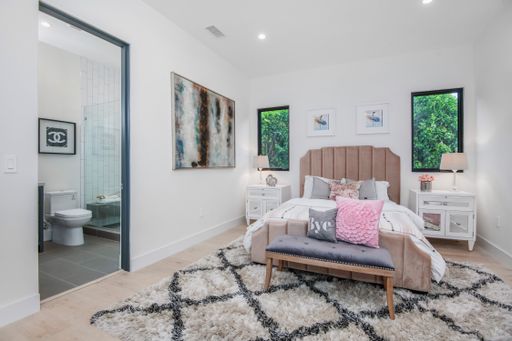 A spacious white bedroom with a large bed and clean decor