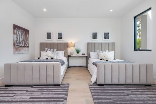 A spacious bedroom with two double beds in a modern new construction home in Los Angeles