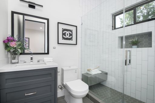 A compact bathroom with toilet, sink, and shower area in a modern new construction home in Los Angeles
