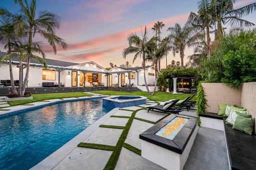 A spacious backyard pool with palm trees in a modern new construction home in Los Angeles