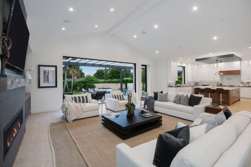 A living room with white sofas and a coffee table in a modern new construction home in Los Angeles
