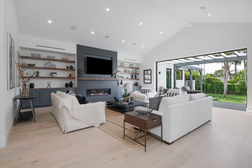 A living room with big screen TV and patio view in a modern new construction home in Los Angeles