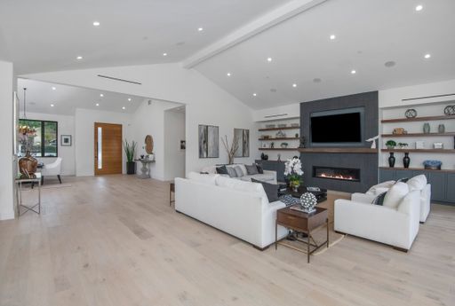 A spacious living room with white sofas in a modern new construction home in Los Angeles