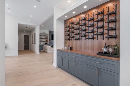 THe shelves filled with bottles against a wall in a modern new construction home in Los Angeles