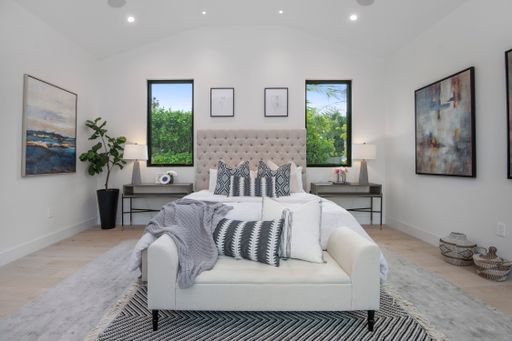 A bedroom with a white bed in a modern new construction home in Los Angeles
