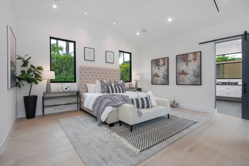 A spacious bedroom with multiple windows in a modern new construction home in Los Angeles