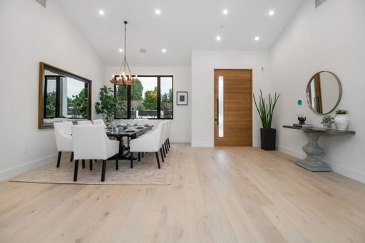 A dining area with a lengthy table in a modern new construction home in Los Angeles