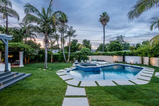 A backyard pool in a verdant garden setting in a modern new construction home in Los Angeles