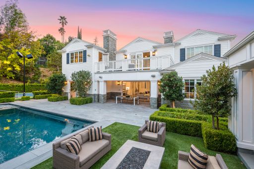 A large pool in front of a white house in Encino, California
