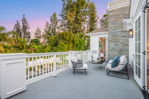 A balcony adorned with multiple chairs in a new construction home in Encino, California