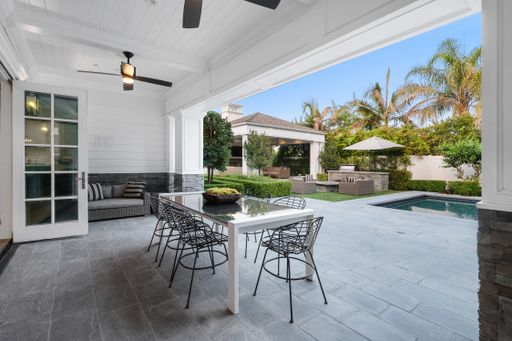 A poolside patio with outdoor dining table in a new construction home in Encino, California