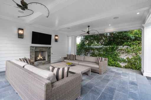 A living room with sofas, TV, and fireplace in a new construction home in Encino, California