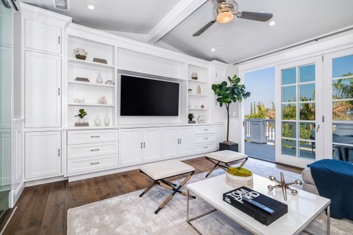 Room with expansive windows, TV, and blue chair