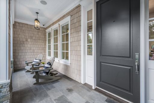 A front porch with a black door in a new construction home in Encino, California