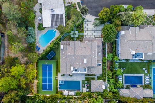 An aerial view of houses and tennis courts in a residential area in Encino, California