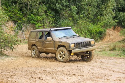 A muddy Jeep Cherokee off-roader 4x4 overlanding offroad