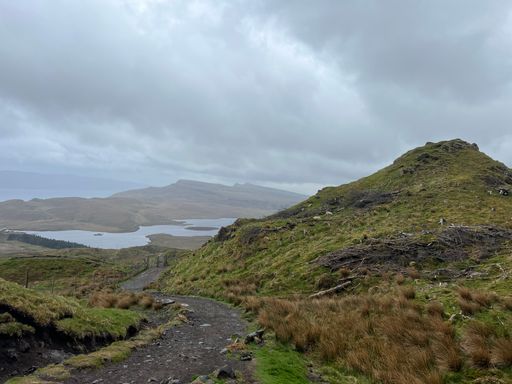 An aerial view of lake and grassy field from hilltop in Scotland