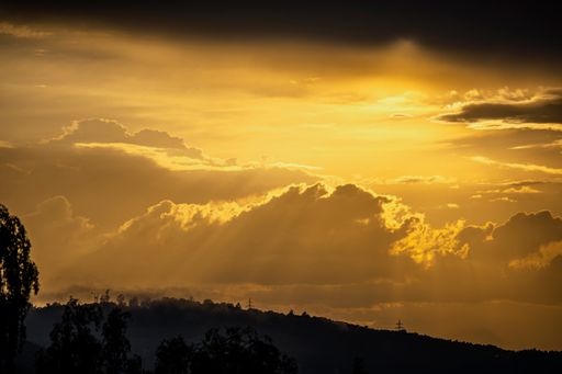 A scenic view Of mountains and trees against sky during sunset
