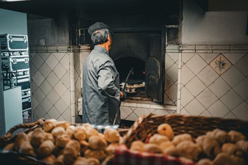 A senior man stands in kitchen with oven in background