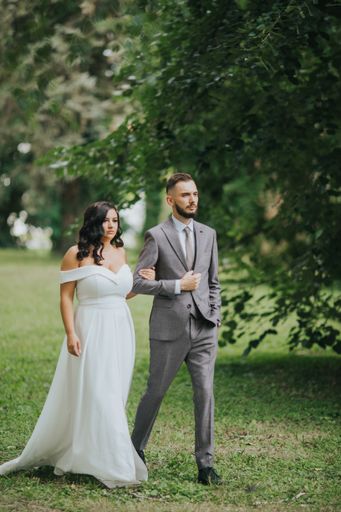 A beautiful newly-married couple posing in a park for the wedding photoshoot