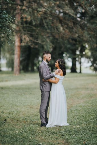 A beautiful newly-married couple posing in a park for the wedding photoshoot