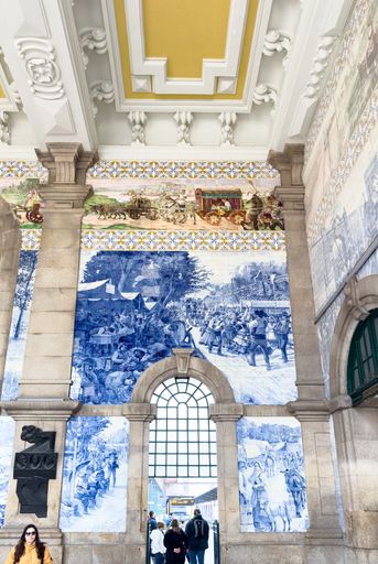 The interior of Sao Bento railway station in Porto is a 20th-century railway terminal with large panels of around twenty thousand azulejo tiles