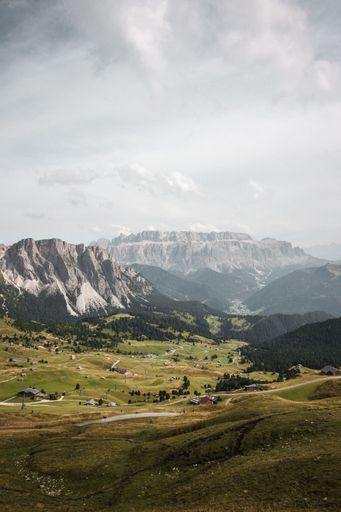 An aerial view of the valley with green grass and trees from the hilltop