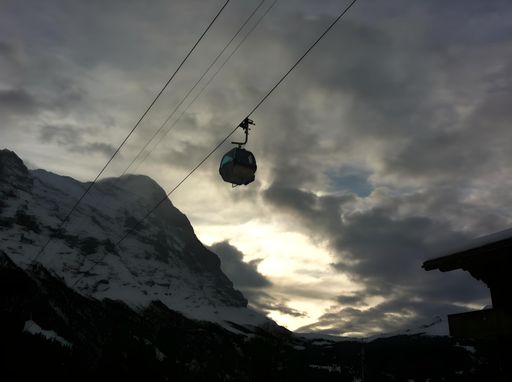 A shot of the Swiss Alps, looking up high into the sky with a gondola making it's way up the mountain. Taken from Grindelwald, base of the Mountains