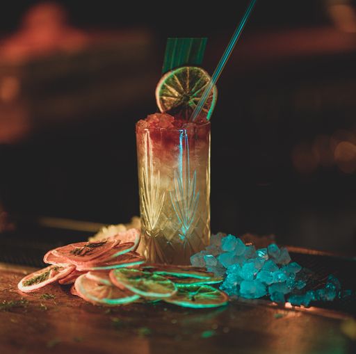 A closeup shot of a classic orange cocktail on a wooden table with ice and dry orange slices