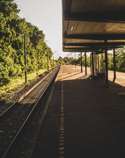 A vertical shot of a small outdoor train station on a sunny day