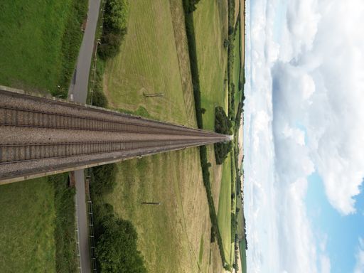 An aerial of the beautiful bridge in Viaduct in Southern England surrounded by green fields
