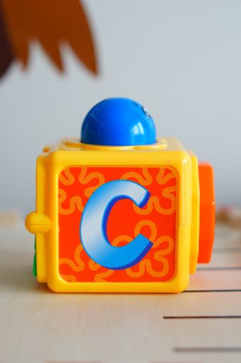 A Fisher-Price plastic toy block with letter C