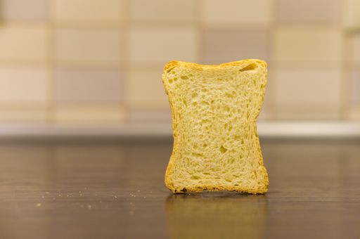 A slice of toasted bread on the wooden surface