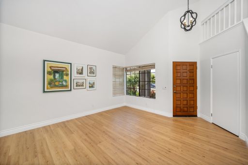 Spacious entry hall with white walls, wooden floors, and artwork on display