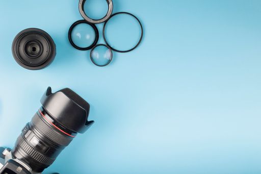 A top view of camera, lenses, and scissors on a table