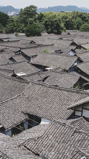 A vertical high angle shot of the identical roofs of small houses in a poor district