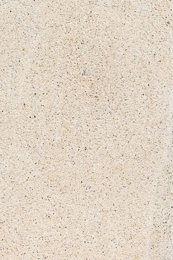 A vertical shot of a rough beige stone surface