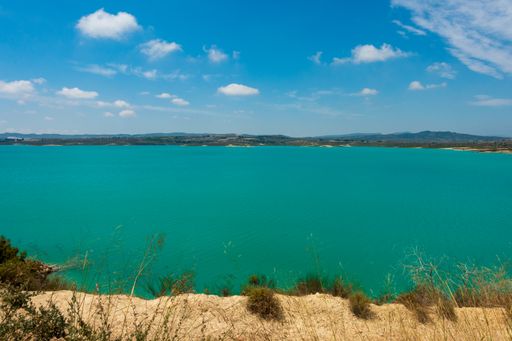 A scenic view of the Torremendo reservoir in Spain under a blue sky