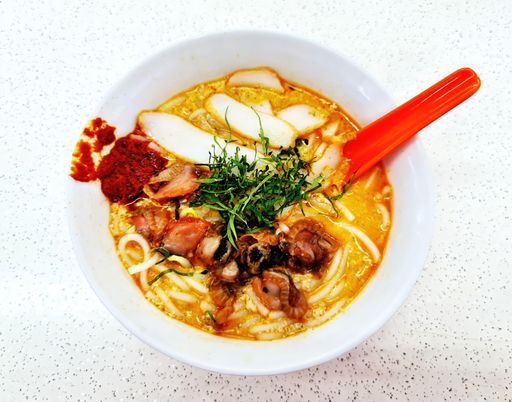 A top view of traditional Singapore Laksa with coconut milk and vegetables