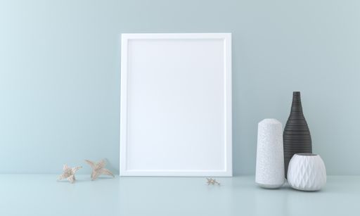 A blank picture frame and vases on a table