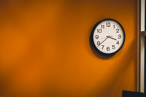 Clock on office wall next to door with small desk