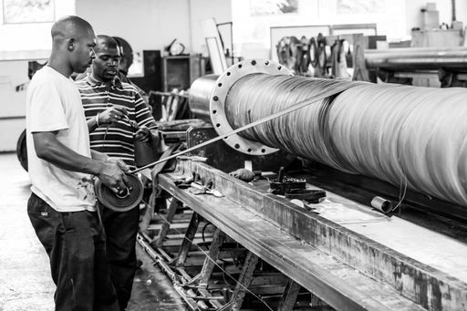 The orkers in factory examining machinery together in Johannesburg, South Africa