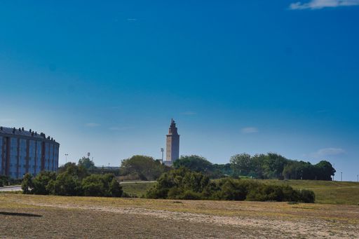A beautiful shot of a field with a building in the distance in Coruna, Spain