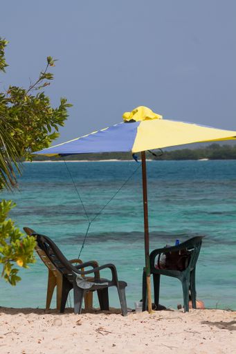 A vertical shot of chairs and an umbrella on a Venezuelan beach