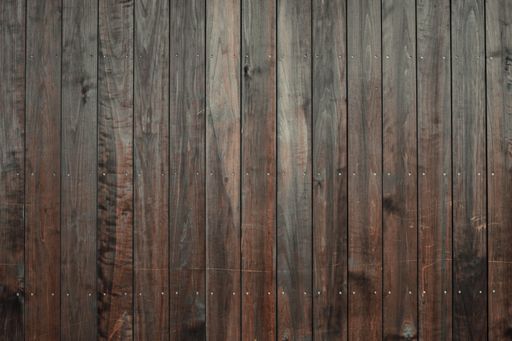 A closeup shot of a wooden floor with dark brown vertical tiles